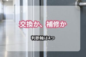 工場の通路にある金属製の扉とアルミ製の枠。表面の塗装が摩耗し、扉の縁に細かい傷が見えている