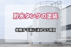 貯水タンクの塗装 依頼する前に決める5項目の文字が入った、工場脇に立つ白く塗装された鋼製貯水タンク